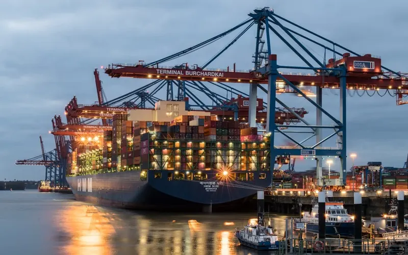 A container ship at a port terminal at dusk